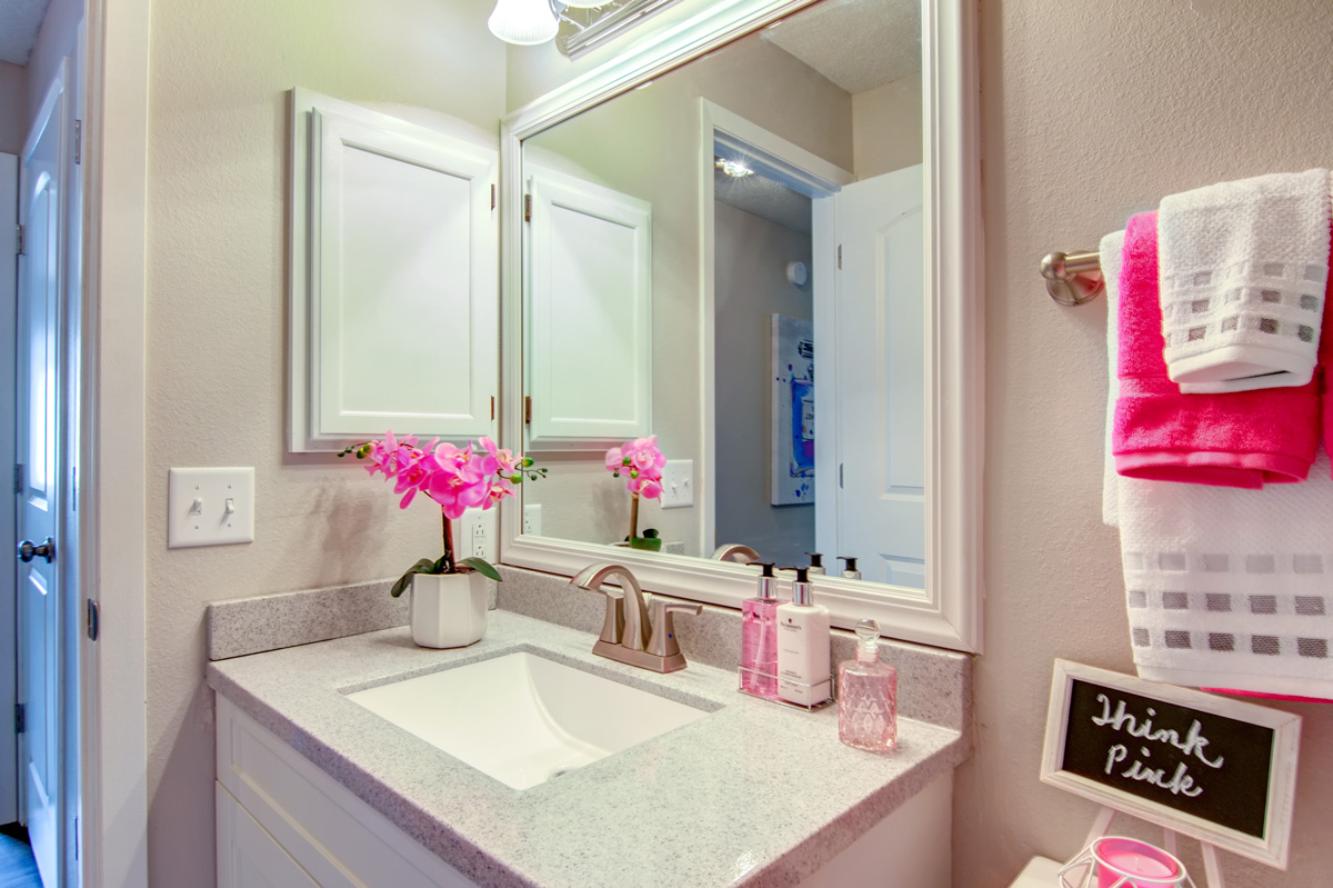 Bathroom sink with pink colored decor.