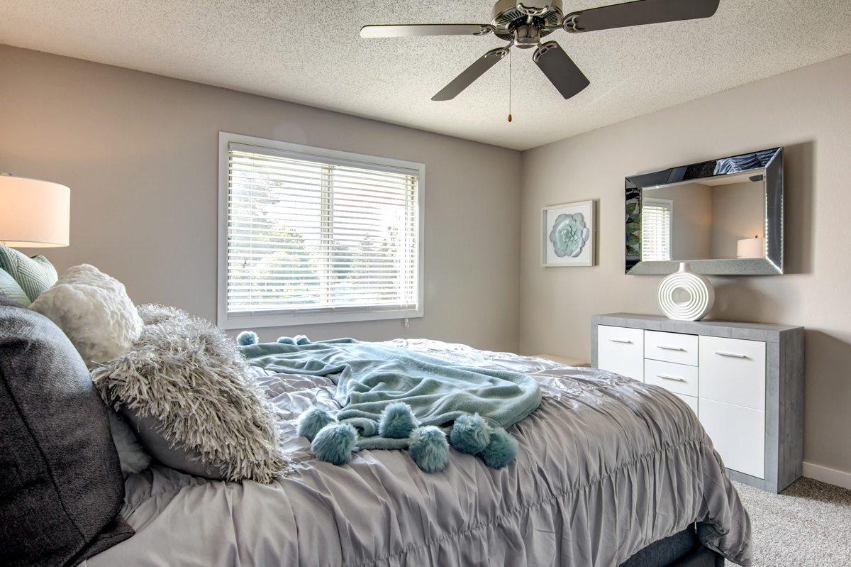 Bedroom with queen bed, ceiling fan, and decorative decor.